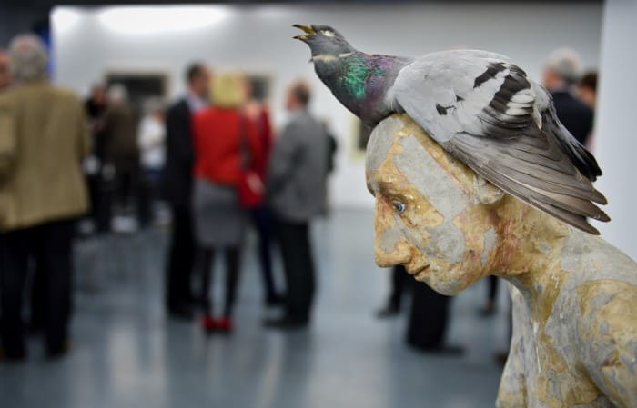 Skulptur einer jungen Frau mit einer unförmigen Taube auf dem demütig gesenkten Kopf. Foto: Andreas Greiner-Napp
