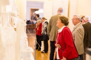 Ausstellungsbesucher betrachten Taufkleider-Galerie. Foto: Schlossmuseum/Marek Kruszewski