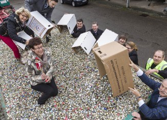 Die Unterstützer und Förderer der Kronkorken-Aktion füllen eigenhändig den Container.