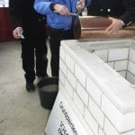 Mit der Platte wurde die Kupferhülse von den Polieren Helmut Hesse (links) und Joachim Schneider eingemauert. Foto: Braunschweiger Zeitung/David Taylor