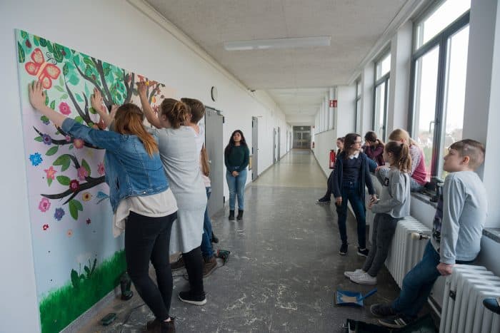 Gemeinsam wurden die bemalten Platten an die Wände geschraubt. Foto: IGS Querum