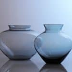 Die vordere Vase zeigt Wilhelm Wagenfelds Entwurf für WMF in den 1950er Jahren. Er entwickelte sie aus der sogenannten Herzvase der Vereinigten Lausitzer Glaswerke aus den 1930er Jahren weiter.