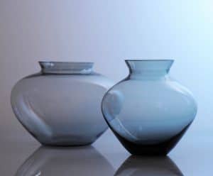Die vordere Vase zeigt Wilhelm Wagenfelds Entwurf für WMF in den 1950er Jahren. Er entwickelte sie aus der sogenannten Herzvase der Vereinigten Lausitzer Glaswerke aus den 1930er Jahren weiter.