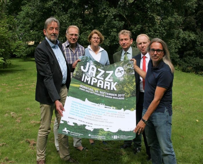 Ulf-Ingo Hoppe (Stiftung Braunschweigischer Kulturbesitz), Projektleiter Klaus Hermann (Sprecher der AG Natur und Umwelt in der Braunschweigischen Landschaft), Gastgeber Verena Freifrau von Münchhausen und Rembert Freiherr von Münchhausen, Mark Knackstedt (Braunschweigische Sparkassenstiftung) und Jan-Heie Erchinger (künstlerischer Leiter) präsentieren das Plakat für „Jazz im Park“. Foto: Braunschweigische Landschaft