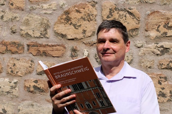 Bauhistoriker Elmar Arnhold mit seinem neuen Buch „Mittelalterliche Metropole Braunschweig“. Foto: Der Löwe