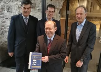 Prof. Dr. Lothar Hagebölling (im Vordergrund) präsentiert als Gesamtherausgeber das Buch „Vom Leyhaus zur Sparkasse“. Im Hintergrund (von links): Axel Richter (Die Braunschweigische Stiftung), Dr. Brage Bei der Wieden (Stiftung Niedersächsisches Wirtschaftsarchiv) und Oliver Ruth (Appelhans Verlag). Foto: DBS