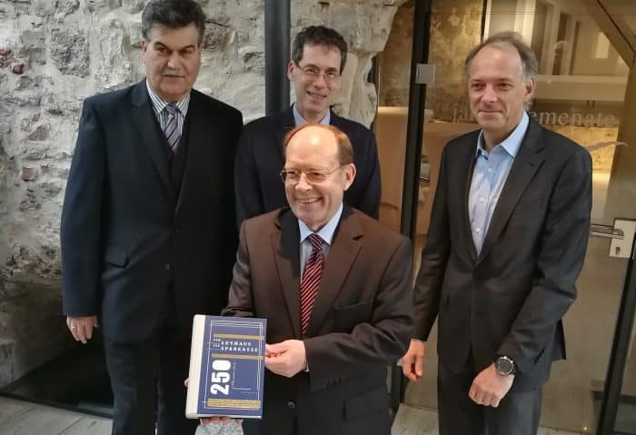 Prof. Dr. Lothar Hagebölling (im Vordergrund) präsentiert als Gesamtherausgeber das Buch „Vom Leyhaus zur Sparkasse“. Im Hintergrund (von links): Axel Richter (Die Braunschweigische Stiftung), Dr. Brage Bei der Wieden (Stiftung Niedersächsisches Wirtschaftsarchiv) und Oliver Ruth (Appelhans Verlag). Foto: DBS