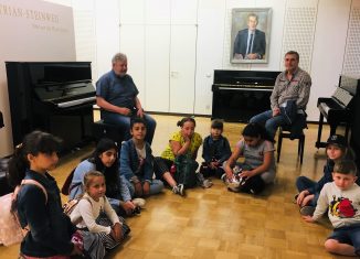 Die Gruppe „Das musikalische Bächlein“ mit Leiter Johannes Rohr (rechts) und Betreuer Roland Heisel beim Besuch der Klavierfabrik Grotrian-Steinweg. Foto: Heidberg Aktiv