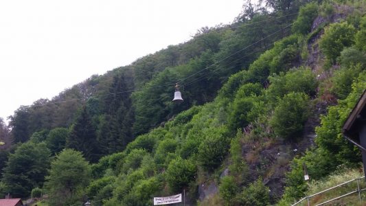 Die alte Glocke wird an der Materialseilbahn nach unten befördert. Foto: Fa. Seilkonzept