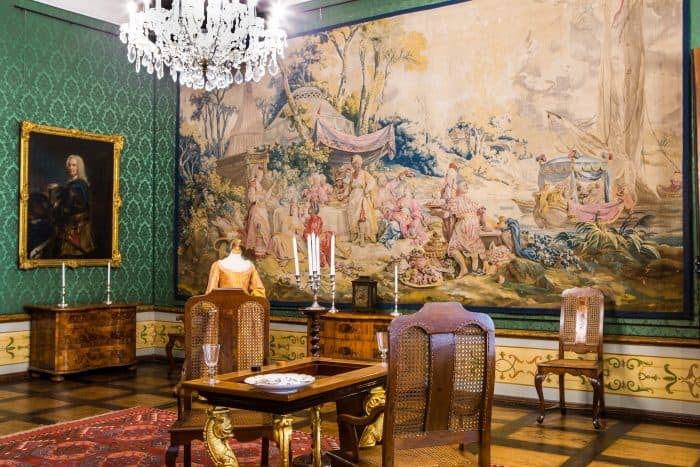 Ein Raum im Herzoginnenappartement mit einem edlen Wandteppich und einem Backgammon-Spieltisch. Foto: Museum Wolfenbüttel / Florian Kleinschmidt.