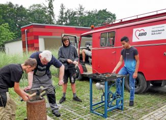 Justin (von rechts), Fabian und Nick werden von Lehrer Michael Werner beim Schmieden angeleitet. Auch externe Schulen können die stationäre Schmiede und das Schmiedemobil nutzen. Foto: Stefan Lohmann / regios24