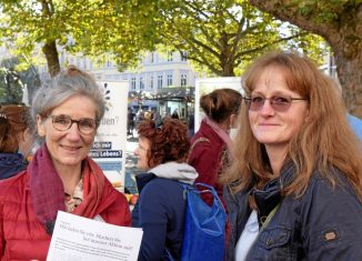 Petra Scholz-Marxen (links), Geschäftsführerin und Koordinatorin des Vereins Hospizarbeit Braunschweig, unterhält sich am Infostand auf dem Kohlmarkt mit ihrem Gast Katrin Sopper, im Hintergrund ist die ehrenamtliche Mitarbeiterin Ann-Kathrin Lumpe ebenfalls in Gesprächen. Foto: Bernward Comes