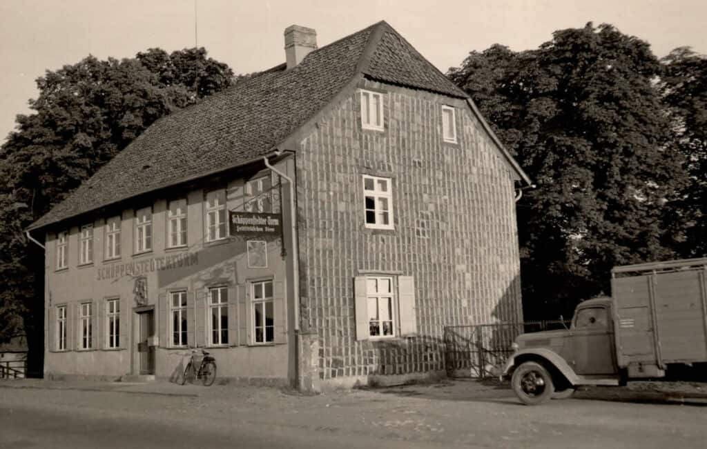 Altes Haus mit Fachwerk, bekannt als "Schöppenstedter Turm", in einer historischen Straßenszene in Deutschland. Um 1930.